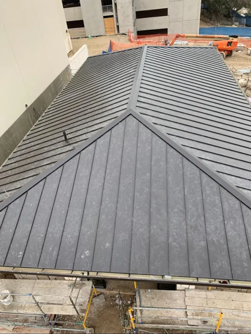 Commercial metal roof construction with crane equipment in Gig Harbor